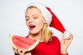 Celebrate new year summer. Girl wear santa hat eat slice watermelon white background. Summer treats on christmas party Royalty Free Stock Photo