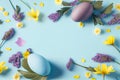 Easter eggs with purple and yellow flowers on pastel Spring blue background Royalty Free Stock Photo