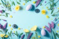 Easter eggs with purple and yellow flowers on pastel Spring blue background Royalty Free Stock Photo
