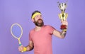 Celebrate victory. Athletic man hold tennis racket and golden goblet. Tennis player win championship. Man bearded Royalty Free Stock Photo