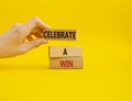 Celebrate a win symbol. Concept words Celebrate a win on wooden blocks. Businessman hand. Beautiful yellow background. Business Royalty Free Stock Photo