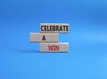 Celebrate a win symbol. Concept words Celebrate a win on wooden blocks. Beautiful blue background. Business and Celebrate a win