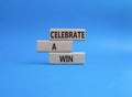 Celebrate a win symbol. Concept words Celebrate a win on wooden blocks. Beautiful blue background. Business and Celebrate a win Royalty Free Stock Photo