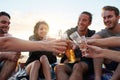 Celebrating another perfect beach day. a group of happy young friends toasting with their drinks while relaxing on the Royalty Free Stock Photo