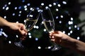 Celebrating Christmas at home, couple clinking glasses with champagne and holding sparklers on background of christmas tree Royalty Free Stock Photo