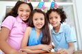 Celebrating a friends birthday. Portrait of three young children at a birthday party. Royalty Free Stock Photo