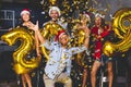 Celebrating New Year party. Group of cheerful young girls in beautiful wearing carrying gold colored numbers 2019 and Royalty Free Stock Photo