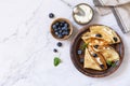 Celebrating Pancake day, healthy breakfast. Delicious homemade crepes with blueberries and ricota on a stone tabletop. Top view Royalty Free Stock Photo