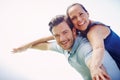 Celebrating their love. A handsome man piggybacking his loving wife outdoors. Royalty Free Stock Photo