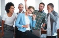 Celebrating their success. Portrait of a group of colleagues cheering while standing in an office. Royalty Free Stock Photo