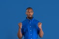 Monochrome portrait of young african-american man on blue studio background