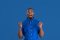 Monochrome portrait of young african-american man on blue studio background