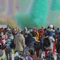 Celebrating winter Holi festival. Colorful powder explosion. Silhouettes of unrecognizable people back to us shooting