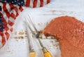 During celebration of America holidays, raw beef steak is preparation on a table draped with flag of United States