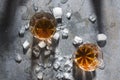 Celebration at the bar.Pair of glasses with alcohol drinks and ice cubes, top view. Glasses with whisky served in the unusual way Royalty Free Stock Photo