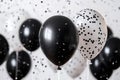 Celebration with black and white balloons and confetti in a festive indoor setting Royalty Free Stock Photo