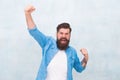 Celebration concept. Brutal handsome hipster man on grey wall background. Bearded man trendy hipster style. Cheerful