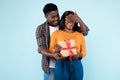 Happy black man making surprise for his woman giving box Royalty Free Stock Photo