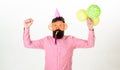 Celebration concept. Man with beard and mustache on busy face blows into party horn, white background. Hipster in giant