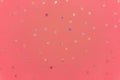 Celebration concept. Multi-colored glitter confetti stars sprinkles on pink trendy background. Festive holiday background for your Royalty Free Stock Photo