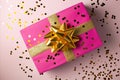 Celebration concept with a pink and gold gift against a polka dot backdrop Royalty Free Stock Photo