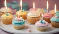 Celebration Cupcakes: Colorful cupcakes with lit candles displayed against a backdrop of wrapped gifts. Captured indoors Royalty Free Stock Photo