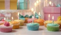 Celebration Cupcakes: Colorful cupcakes with lit candles displayed against a backdrop of wrapped gifts. Captured indoors Royalty Free Stock Photo