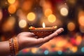 In celebration of Diwali, delicate female hands hold a beautiful candle