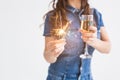 Celebration, drinks and holiday concept - close up of young woman with sparkler and glass of champagne on white Royalty Free Stock Photo