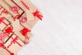 Celebration gifts background - different presents of craft paper wrapped with red ribbons and bows, blank labels on white wood. Royalty Free Stock Photo