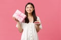 Celebration, party holidays and fun concept. Lovely asian girl in white dress celebrating birthday, holding gift and b Royalty Free Stock Photo