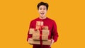 Happy asian guy holding stack of present boxes Royalty Free Stock Photo