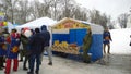 Celebration and tradional trade fair in the city park. Crowd of people. Market stall with farm honey. Cold weather, sleet. Real li