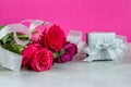 Celebratory background of roses and a silvery gift box with ribbon