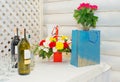 Celebratory table with flowers boutique and alcohol. Beautiful bunch of flowers on the table with glasses and bottles for booze Royalty Free Stock Photo