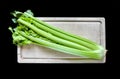 Celery branch bunch on a cutting board isolated on black