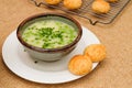 Celery cream soup with a green pea in a bowl garnished with chopped green onion and served with freshly baked cheese bread close- Royalty Free Stock Photo