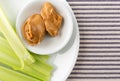 Celery stalks with peanut butter on a white plate Royalty Free Stock Photo