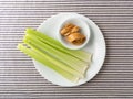 Celery stalks with peanut butter on a white plate Royalty Free Stock Photo