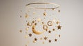 a celestial-themed mobile with golden stars and crescent moons suspended against a pure white backdrop