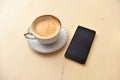 Cell phone and coffee cup on a vintage table Royalty Free Stock Photo