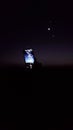 Cell phone held up to nighttime celestial alignment of Venus, Moon, Jupiter