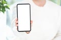Cell phone mockup. woman in white clothes shows blank white cell phone screen. Mobile phone with white screen in female hand Royalty Free Stock Photo