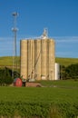 Cell tower and grain silo with green field Royalty Free Stock Photo