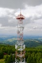 Cell tower with GSM receiver, transmitter. Aerial view of steel radio mast construction with telecom antenna against dramatic sky.