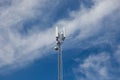 A cell tower set against a blue sky, a modern silver metal construction with white panels to keep your phone signal uninterrupted Royalty Free Stock Photo