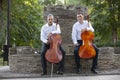 Cellist musician group perform music in the street, close up man playing violin