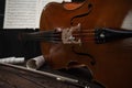 The cello lies on a wooden surface with a bow and music stand. Place for text Royalty Free Stock Photo