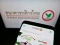 Cellphone with company website of Thai bank Kasikornbank PCL (KBank) on screen in front of business logo. Royalty Free Stock Photo