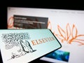 Cellphone with logo of academic publishing company Elsevier on screen in front of business website.